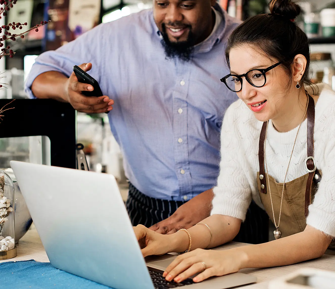 black man and white woman on phone and laptop doing business