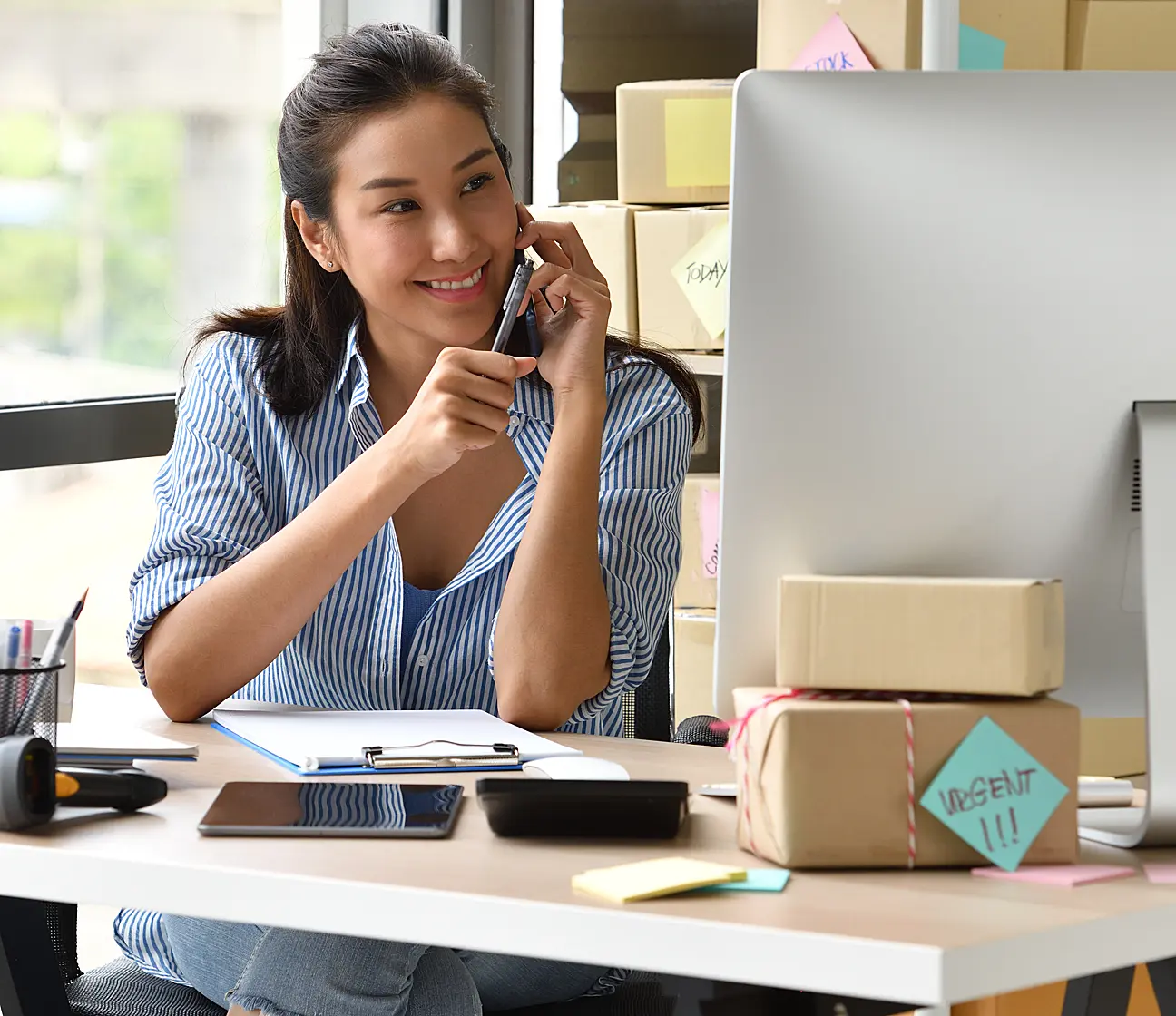 spanish woman on phone looking at desktop pc
