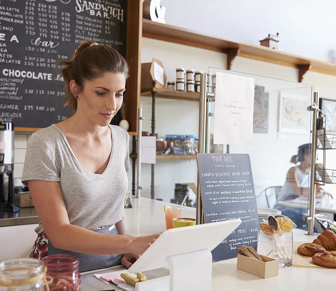 white woman behind checkout at cafe